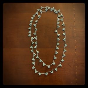 Long silver chain with faux pearls.